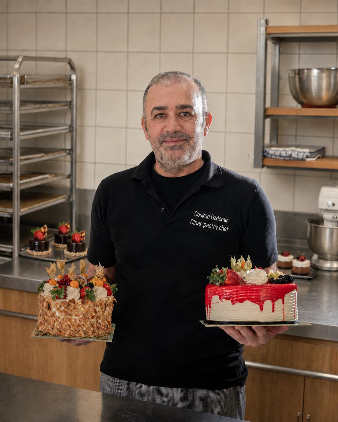Coskun Ozdemir holding two decorated cakes.